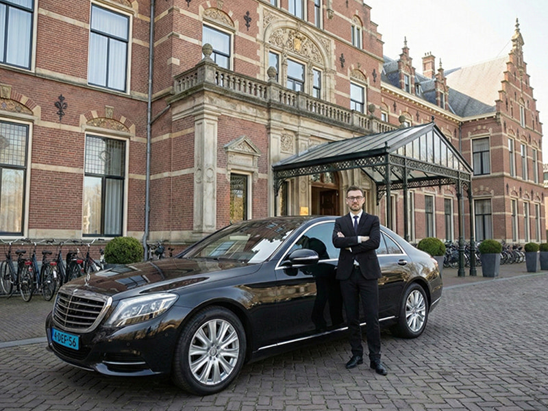 car with driver near old building