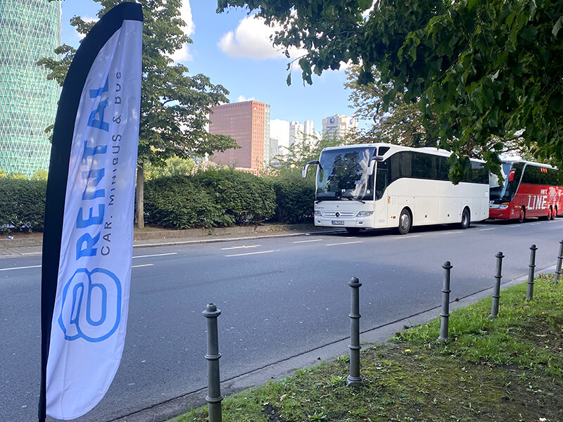 coach with 8rental flag waiting for people
